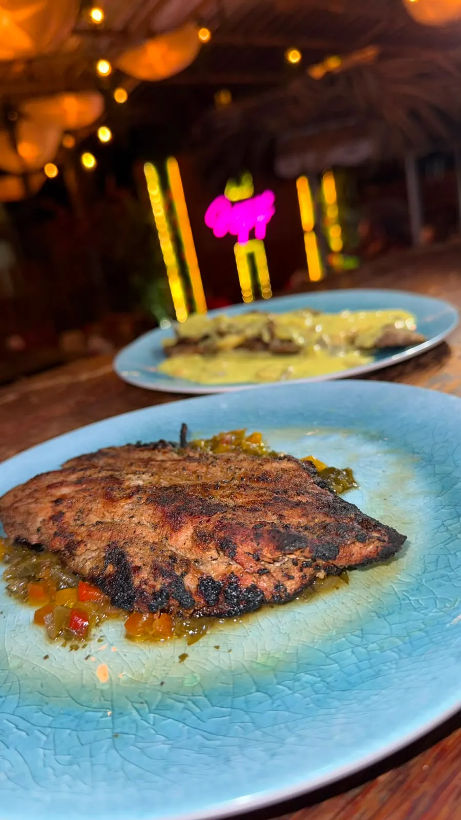 Churrasco a la parrilla sobre una cama de vegetales salteados.