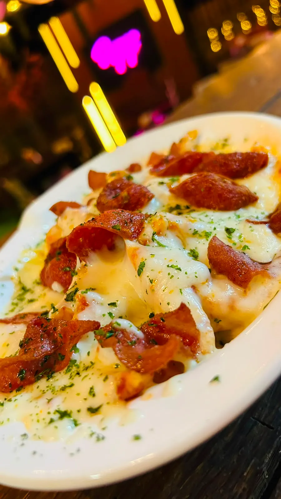 Papas cargadas, gratinadas con queso cremoso y tocineta.