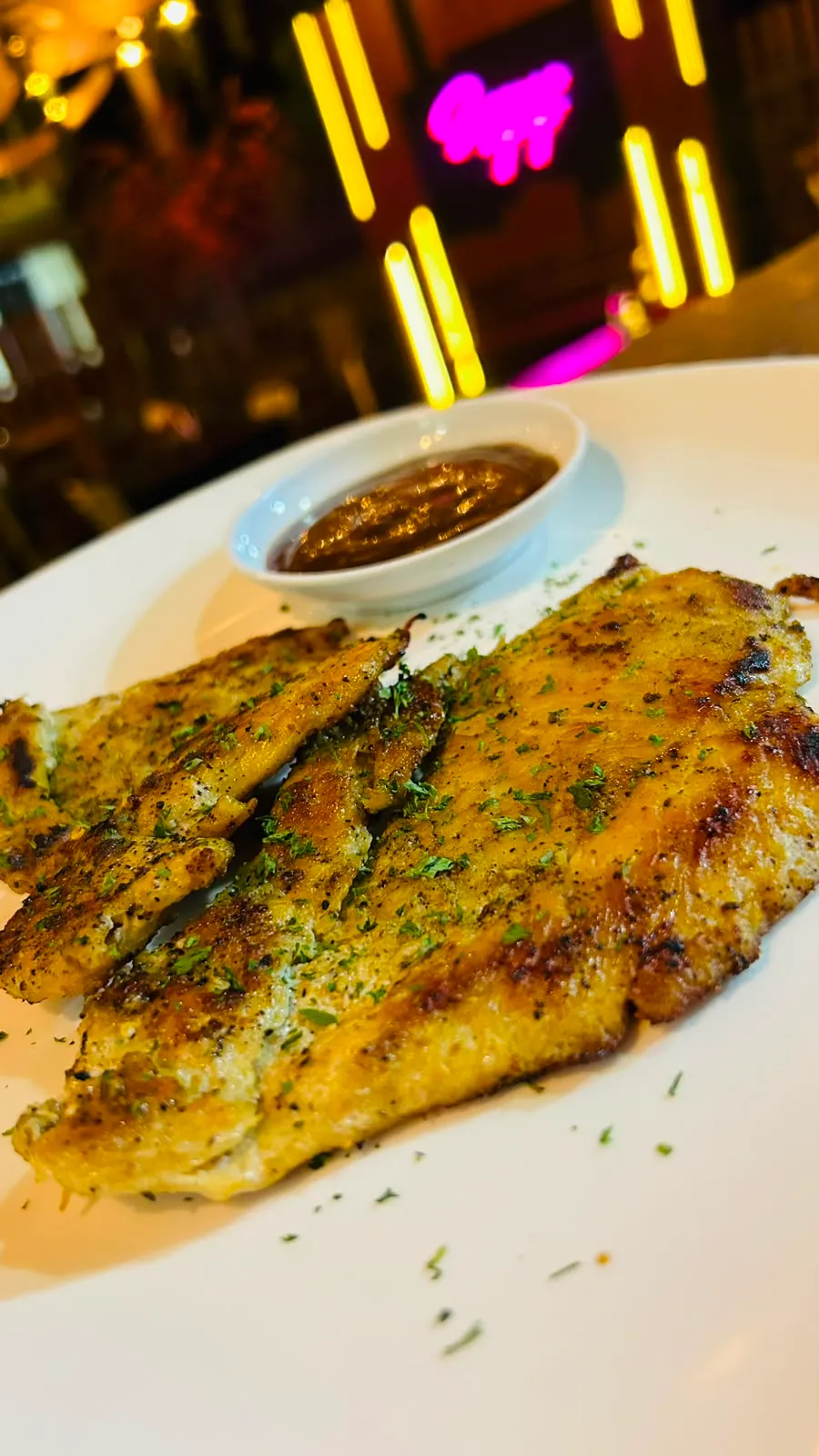 Filete de pescado a la parrilla con especias y salsa de la casa.